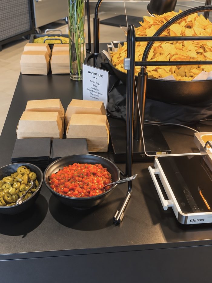 Nacho-Bar mit Tortilla-Chips, Salsa und Jalapeños
